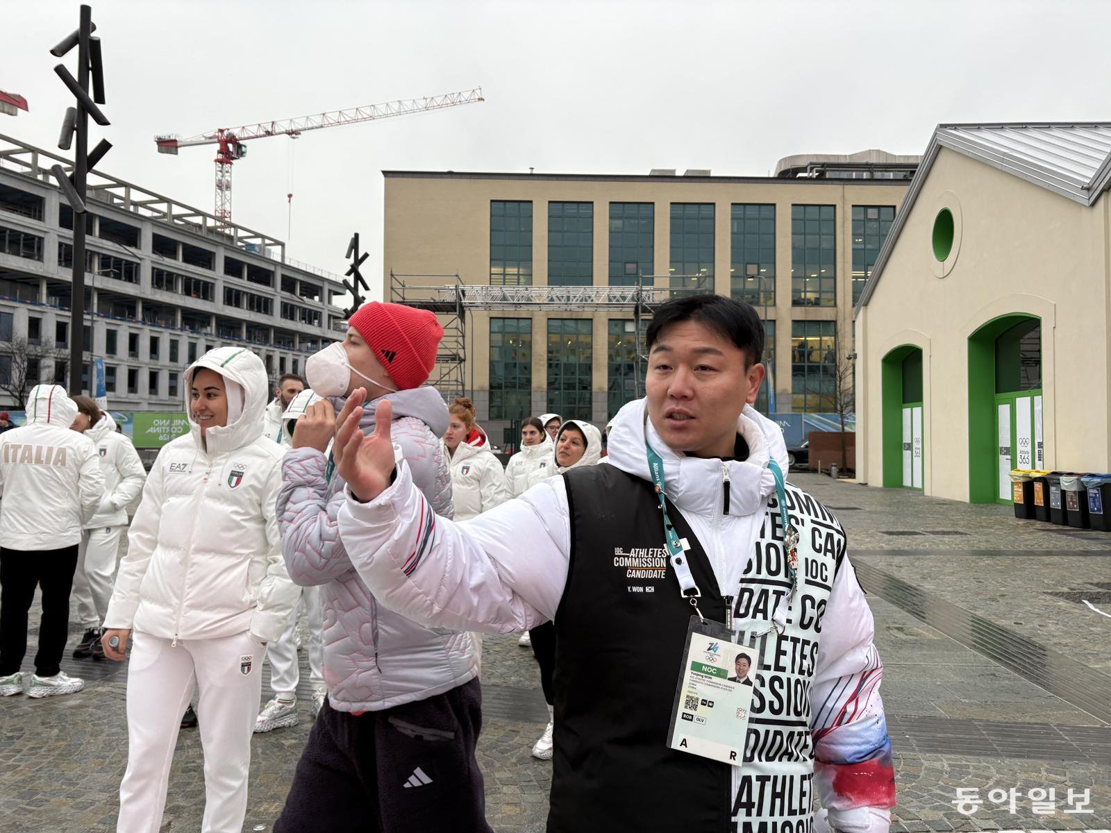 원윤종 국제올림픽위원회(IOC) 선수위원 후보가 밀라노 올림픽 선수촌 중앙 광장에서 후보 신분을 나타내는 조끼를 입은 채 유세를 벌이고 있다. 매일 오전 7시부터 선수촌에 출근 도장을 찍는 그는 오후 10시가 넘어 퇴근한다. 선수들의 투표 시간은 오전 8시~오후 10시다. 밀라노=임보미 기자 bom@donga.com
