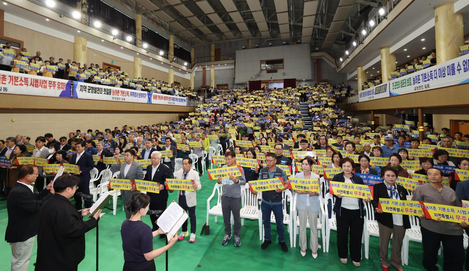 지난해 10월 전북 무주군 무주 예체문화관 대강당에서 열린 농어촌 기본소득 시범 사업 선정 촉구 범군민 결의대회에서 참석자들이 염원을 담은 퍼포먼스를 하고 있다. 무주군은 정부 공모에서 탈락한 뒤 자체 기본소득 시범 사업 추진을 밝힌 데 이어 최근 보건복지부와 사업 추진을 위한 협의를 마무리했다. 무주군 제공