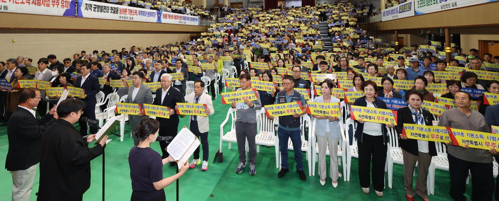 지난해 10월 전북 무주군 예체문화관 대강당에서 열린 농어촌 기본소득 시범 사업 선정 촉구 범군민 결의대회에서 참석자들이 염원을 담은 퍼포먼스를 하고 있다. 무주군은 정부 공모에서 탈락한 뒤 자체 기본소득 시범 사업 추진을 밝힌 데 이어 최근 보건복지부와 사업 추진을 위한 협의를 마무리했다. 무주군 제공