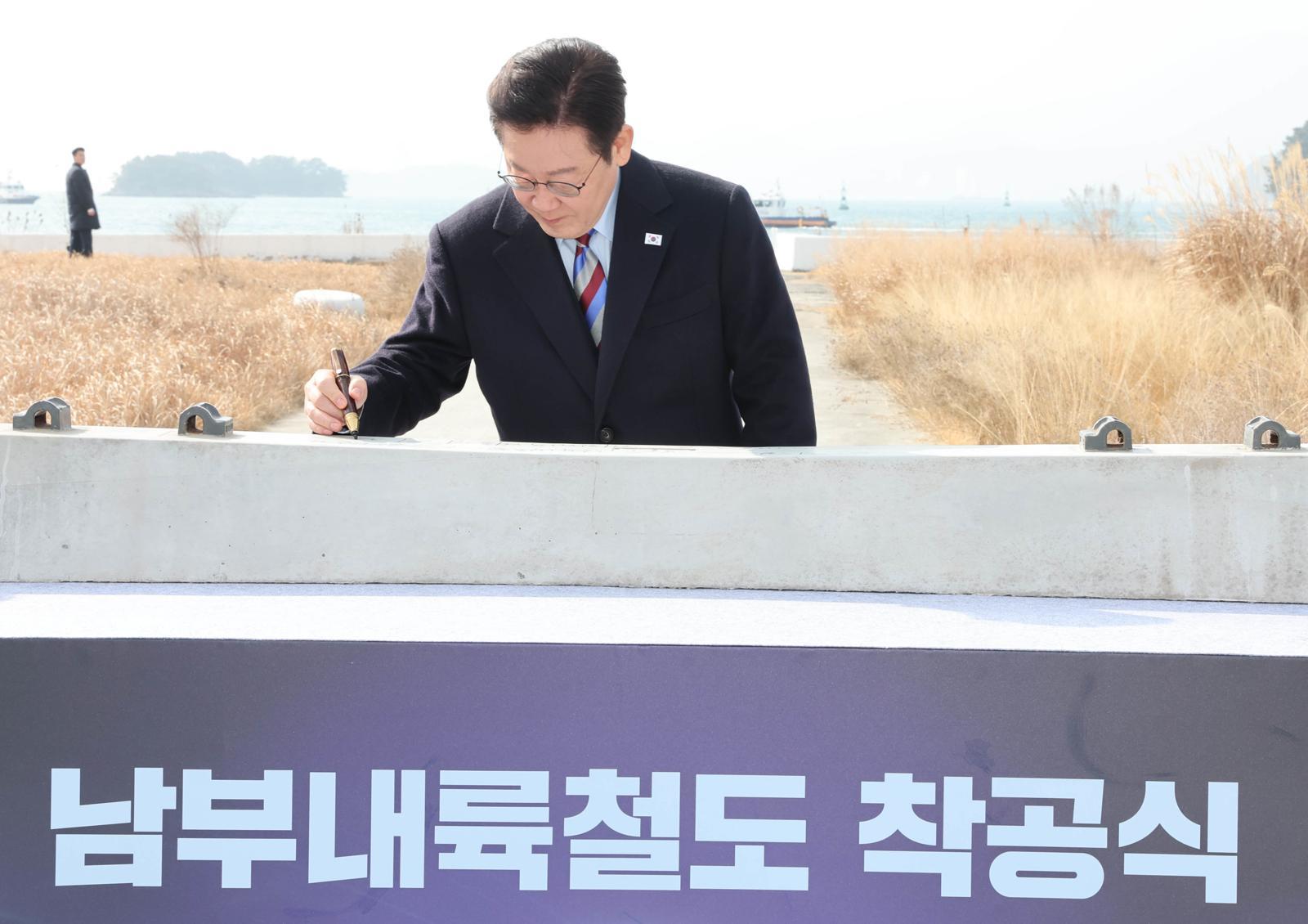 이재명 대통령이 6일 경남 거제시 견내량 인근에서 열린 남부내륙철도 착공식에서 침목 서명식을 하고 있다.  2026.2.6/뉴스1