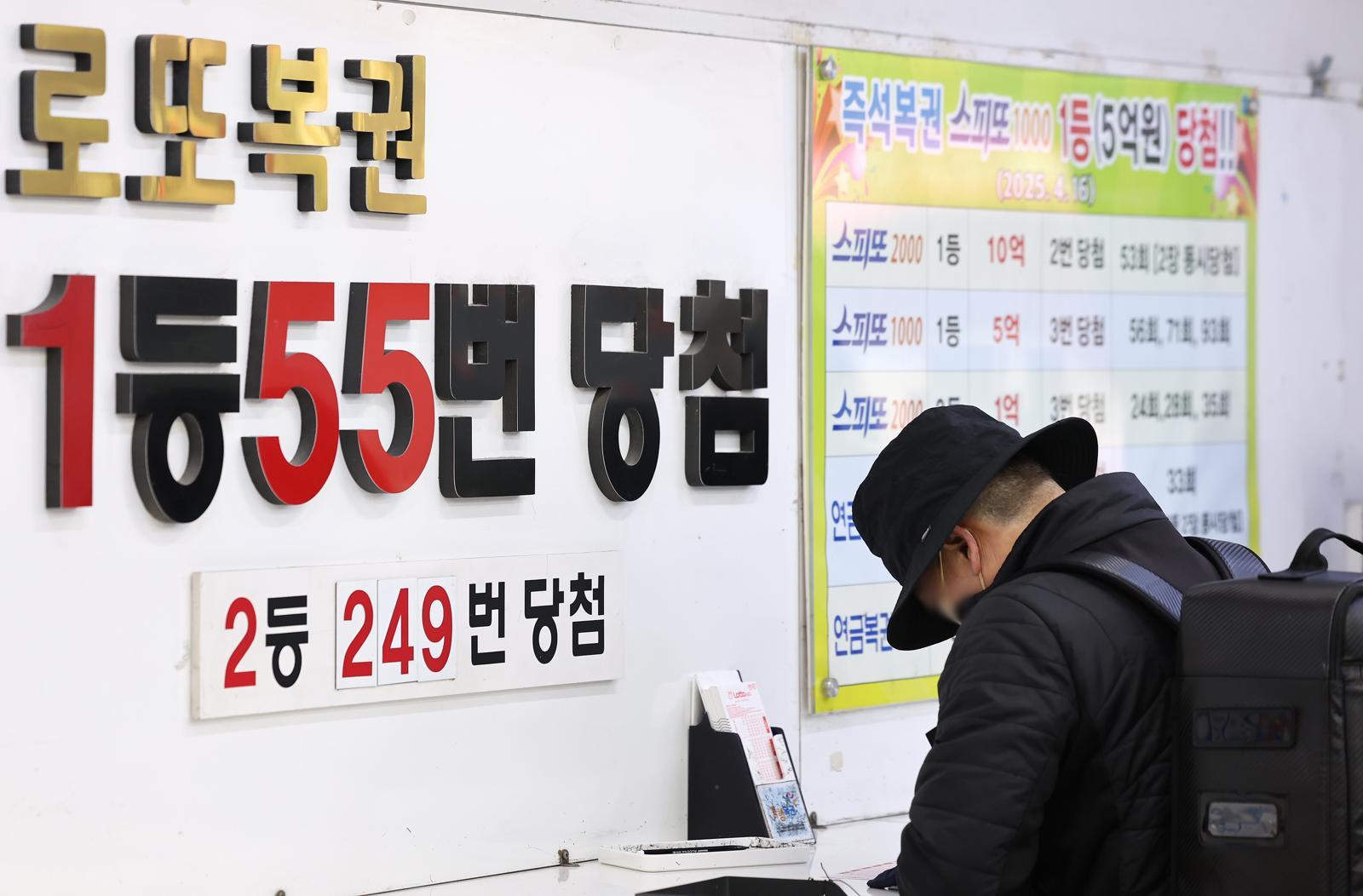 서울 노원구에 위치한 복권 판매점을 찾은 시민이 복권을 구매하고 있다. ⓒ News1