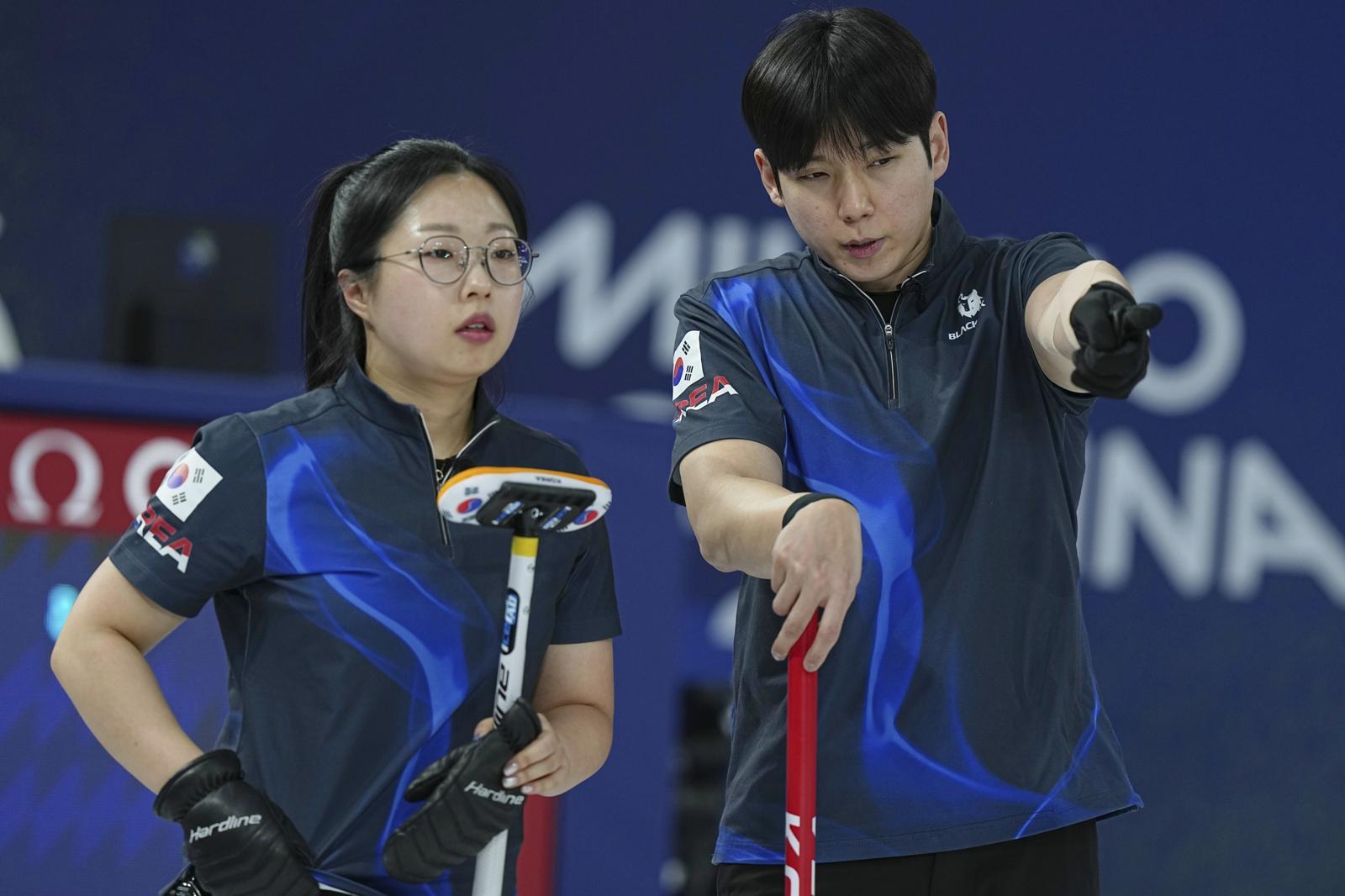 South Korea‘s Kim Seon-yeong, left, and Jeong Yeong-seok strategize during the mixed doubles round robin phase of the curling competition against the United States at the 2026 Winter Olympics, in Cortina d’Ampezzo, Italy, Saturday, Feb. 7, 2026. (AP Photo/Fatima Shbair)