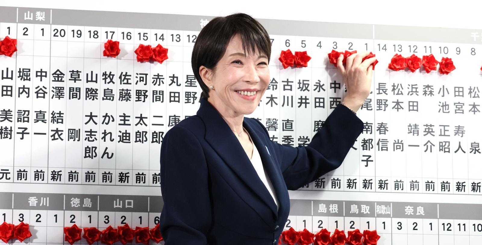 다카이치 사나에 일본 총리가 중의원(하원) 선거가 실시된 8일 도쿄의 자민당 당사에서 승리한 소속 후보들의 이름 위에 붉은 꽃 장식을 달아주며 활짝 웃고 있다. NHK방송에 따르면 자민당은 이날 오후 10시 40분 기준 전체 465석 중 과반(233석) 이상인 256석을 확보했다. 아사히신문 제공