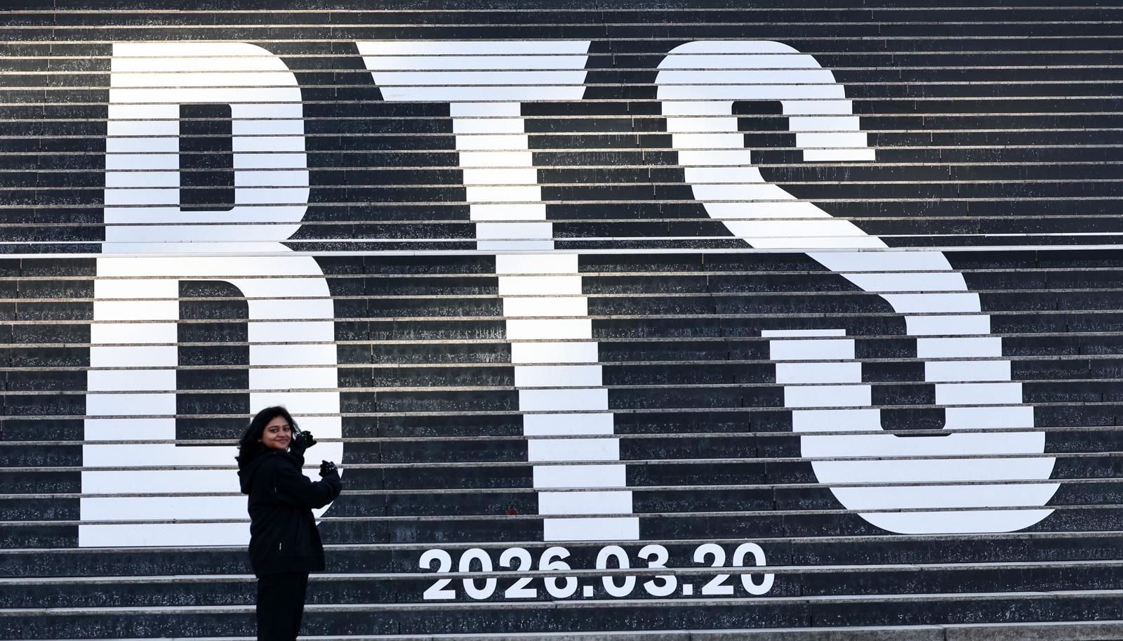 지난달 22일 오후 서울 종로구 세종문화회관 계단에 설치된 방탄소년단(BTS)의 정규 5집 컴백을 알리는 홍보물을 배경으로 관광객들이 기념촬영을 하고 있다./뉴스1