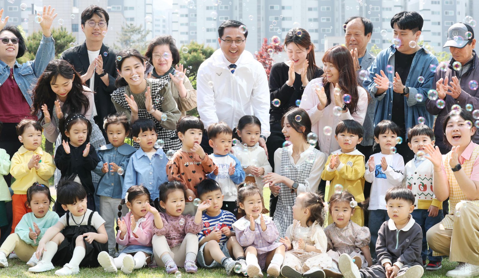 대전 동구는 인구 30만 명 회복을 위해 머물고 정착하는 도시로 전환하고 아이와 가족, 청년 세대를 아우르는 인구정책 추진하고 있다고 10일 밝혔다. 사진은 박희조 구청장(뒷줄 가운데)이 관내 아이들과 버블쇼를 보는 모습. 동구 제공