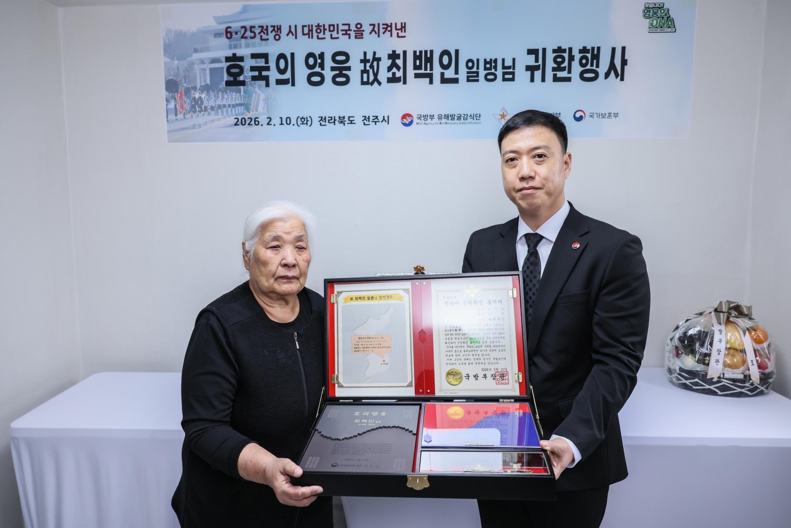 김성환 국방부 유해발굴감식단장 직무대리가 10일 전북 전주에서 열린 호국영웅 고(故) 최백인 일병 귀환행사에서 고인의 여동생 최길자 씨에게 전사자 신원확인 통지서 등이 담긴 호국의 얼 함을 전달하고 있다. (사진=국방부유해발굴감식단 제공) 2026.02.10 뉴시스