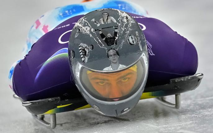 우크라이나 스켈레톤 선수 블라디슬라우 헤라스케비치가 9일 2026 밀라노-코르티나담페초 겨울올림픽 남자 스켈레톤 경기를 앞두고 연습 주행을 하고 있다. 그가 쓴 헬멧에 우크라이나 전쟁으로 인해 희생된 동료 선수들의 얼굴이 새겨져 있다. 코르티나담페초=AP 뉴시스