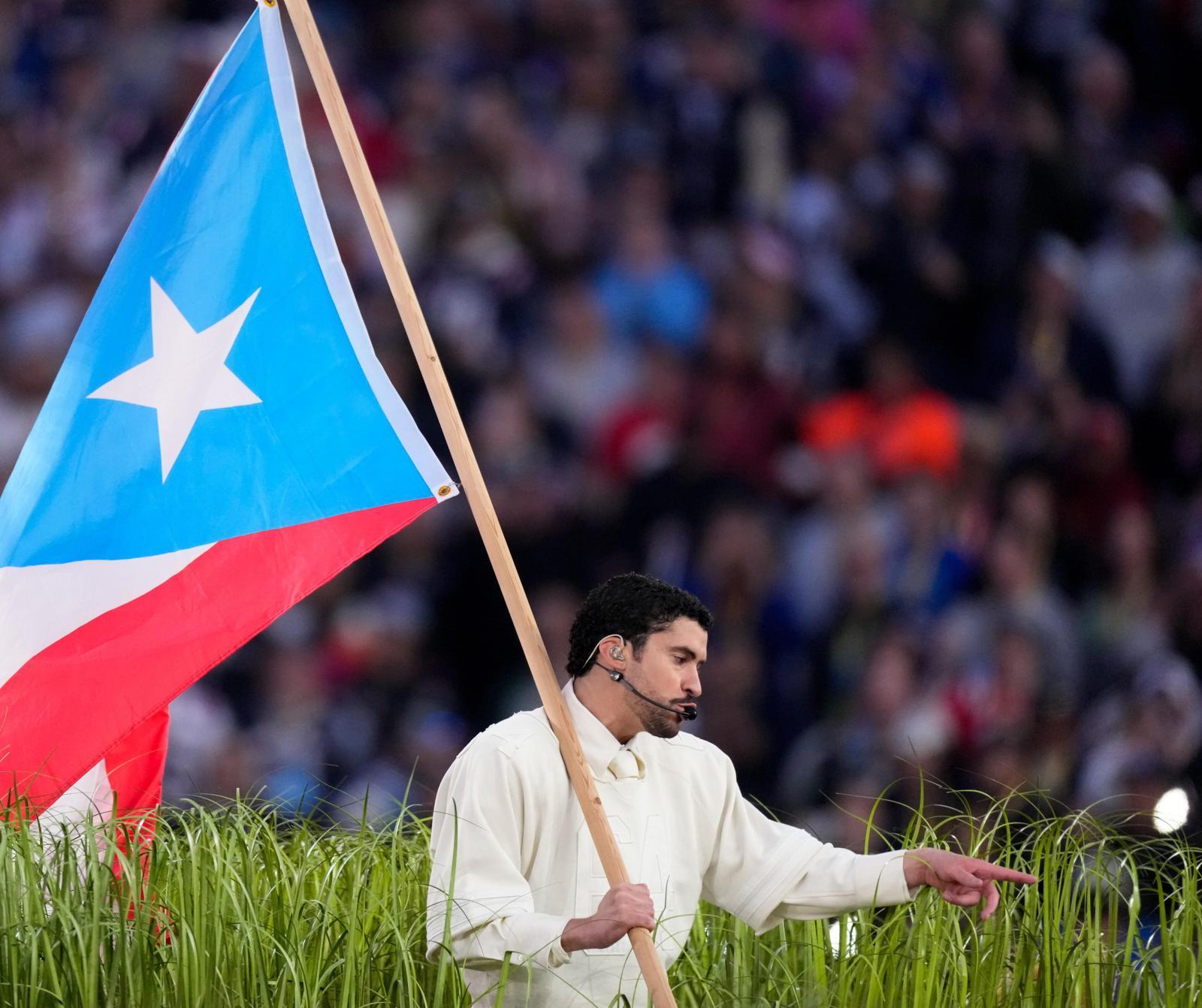 푸에르토리코 출신의 라틴 팝스타 배드 버니가 8일 미국 캘리포니아주 샌타클래라에서 열린 미국프로미식축구리그(NFL) 결승전(슈퍼볼) 하프타임 쇼 무대에서 미국령 푸에르토리코 깃발을 든 채 공연하고 있다. 그는 슈퍼볼 하프타임 쇼 무대 최초로 공연 시간 내내 스페인어로만 노래했다. 샌타클래라=AP 뉴시스