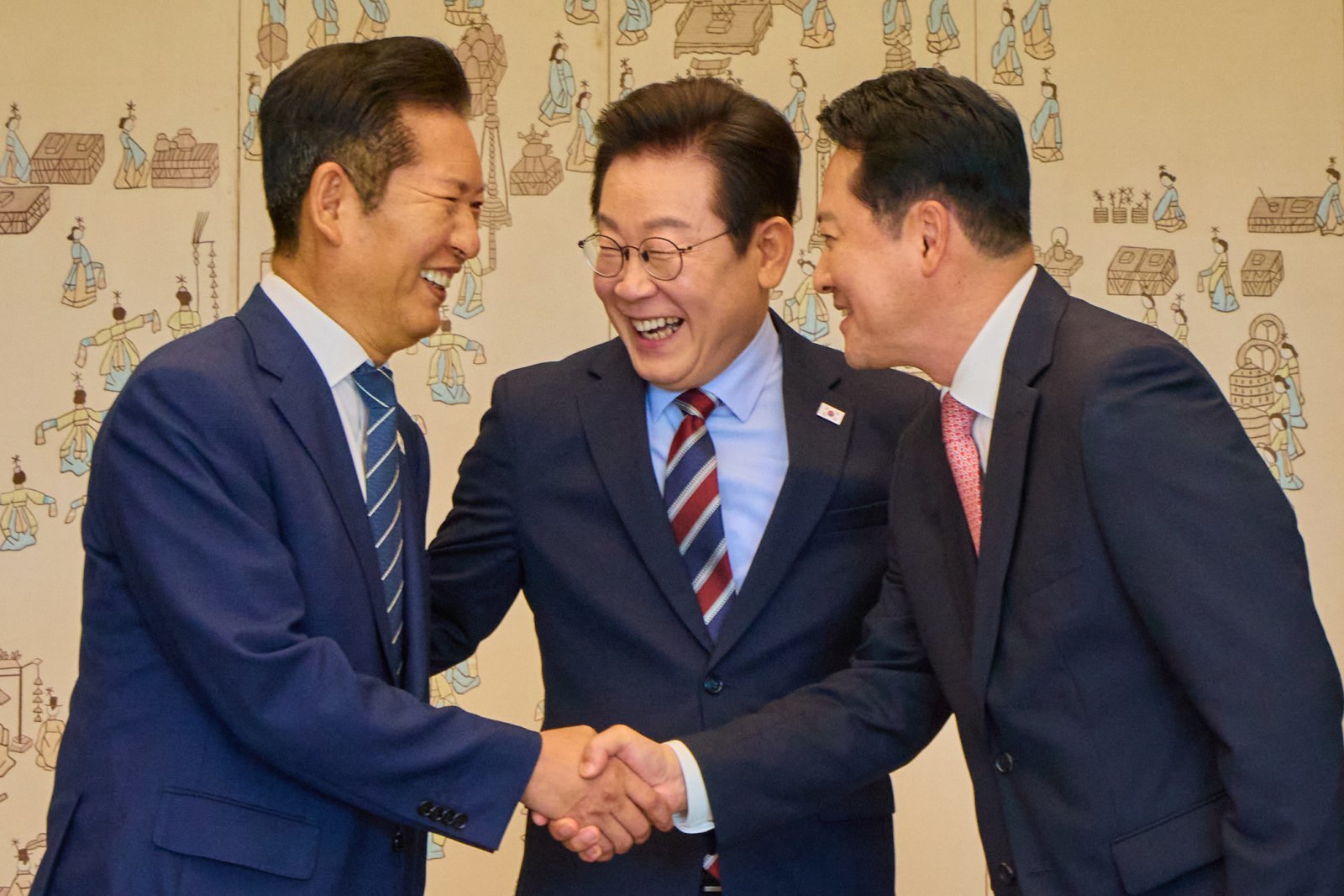 이재명 대통령이 지난해 9월 8일 서울 용산 대통령실 청사에서 열린 여야 지도부 오찬 회동에서 정청래 더불어민주당 대표, 장동혁 국민의힘 대표가 악수하는 것을 보고 미소를 짓고 있다. 2025.9.8 대통령실 제공