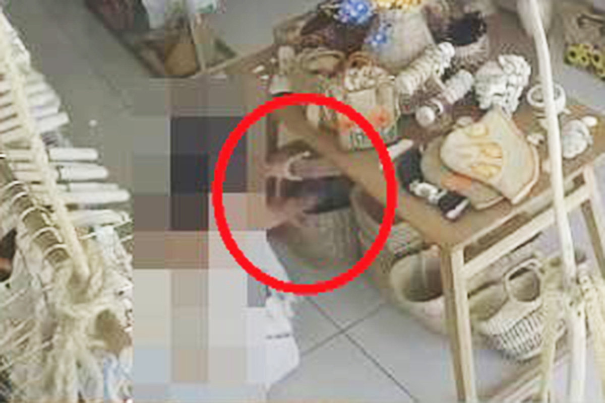 여성 한 명이 점원이 없는 틈을 타 보관함에서 수영복을 꺼내 가방에 넣고 있는 모습. 더 타이거