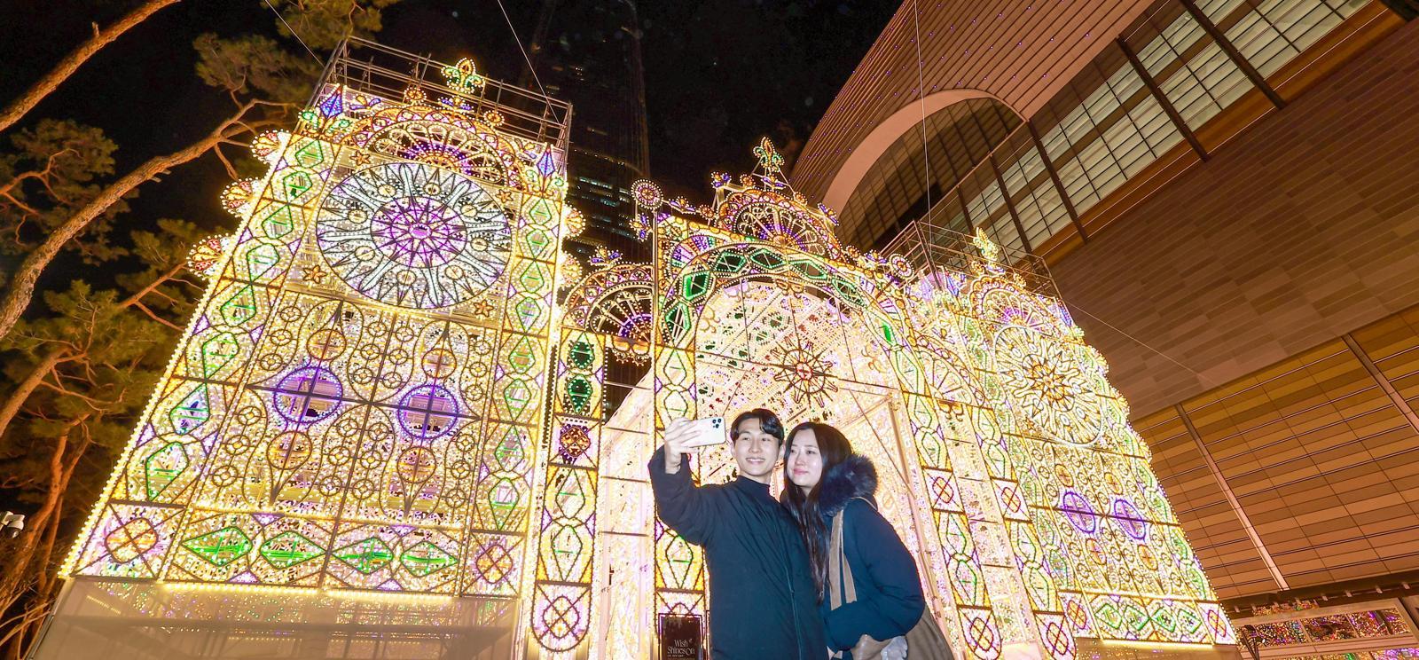 ‘2026 롯데 루미나리에’를 배경으로 추억을 남기는 시민들.