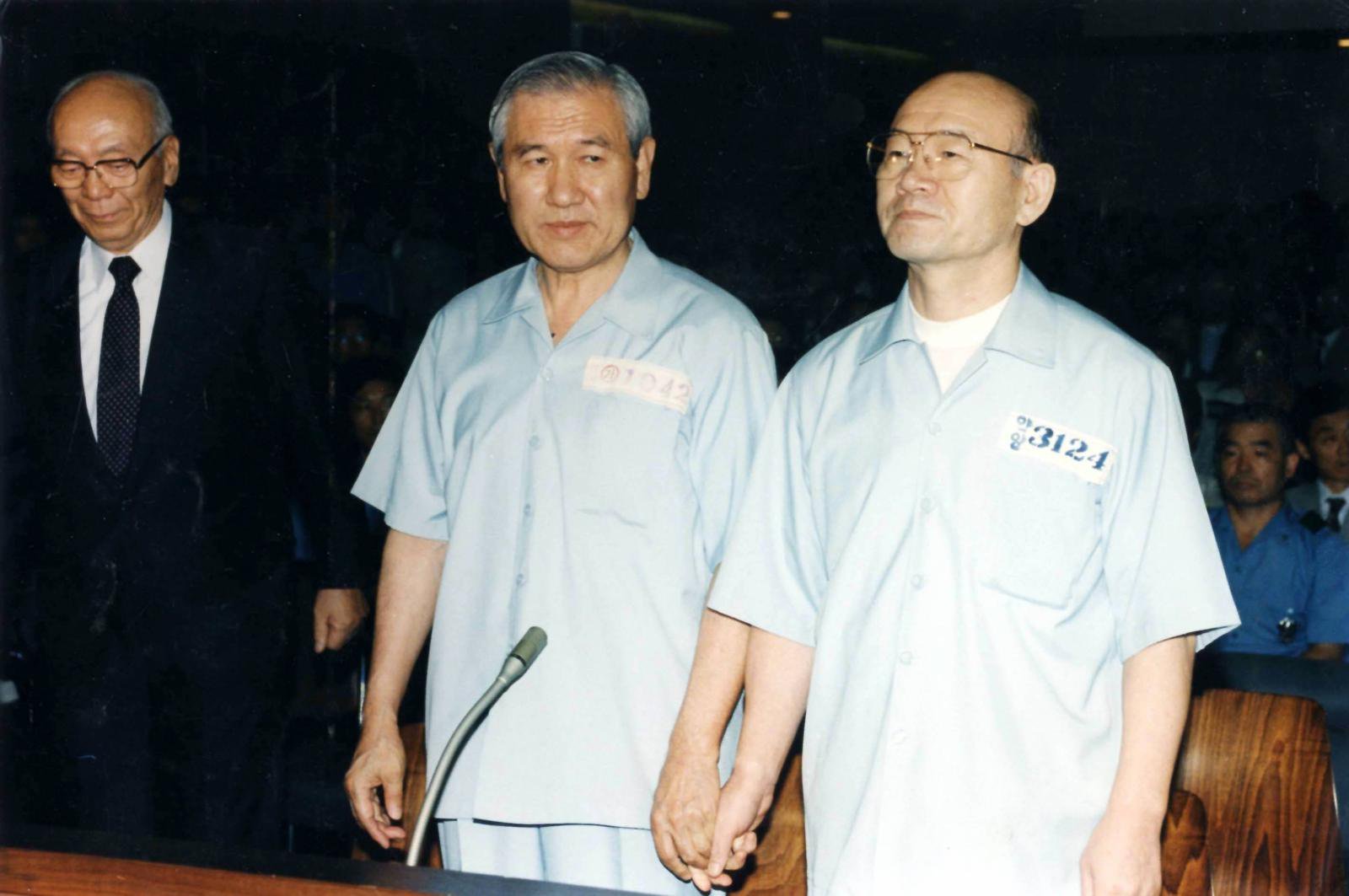 12·12 군사쿠데타와 5·18 민주화운동 유혈 진압을 일으킨 혐의 등에 대한 1심 선고공판이 열린 1996년 서울 서초동 서울지법 417호 대법정에 선 전두환 노태우 두 전직 대통령이 착잡한 표정으로 손을 맞잡고 있다. 동아일보 DB