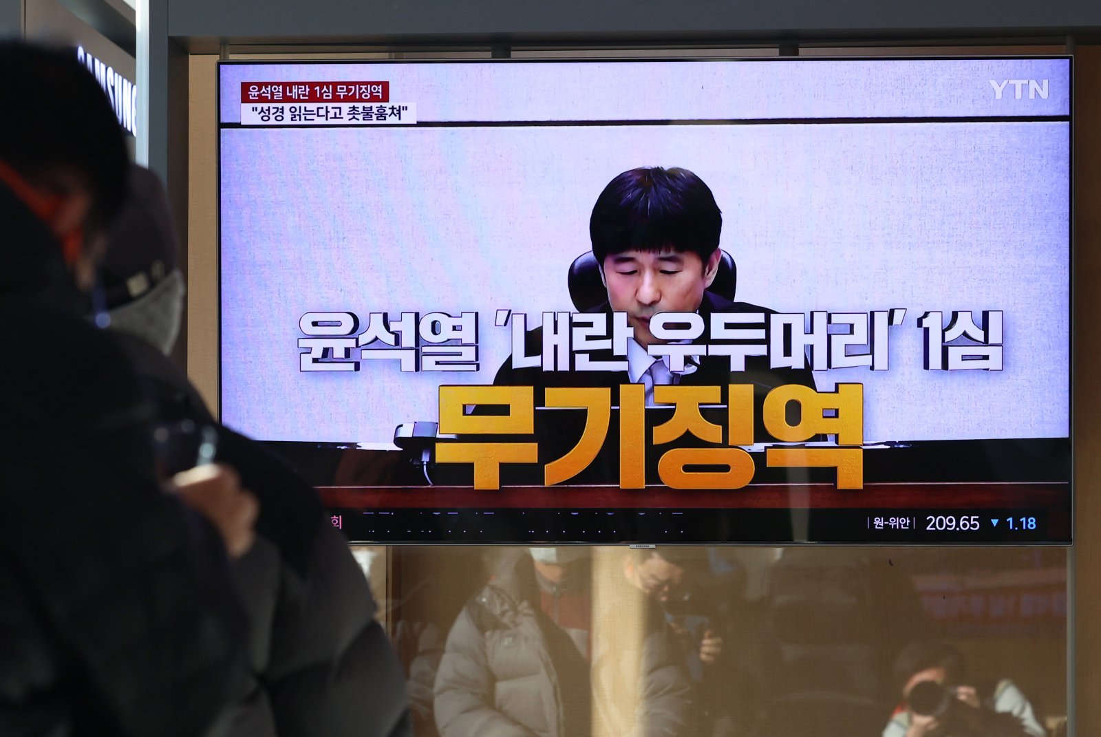 19일 오후 서울 용산구 서울역에서 시민들이 ‘내란 우두머리 혐의’ 윤석열 전 대통령의 1심 선고 공판 중계를 시청하고 있다.   윤 전 대통령은 1심에서 무기징역을 선고 받았다. 2026.02.19 뉴시스