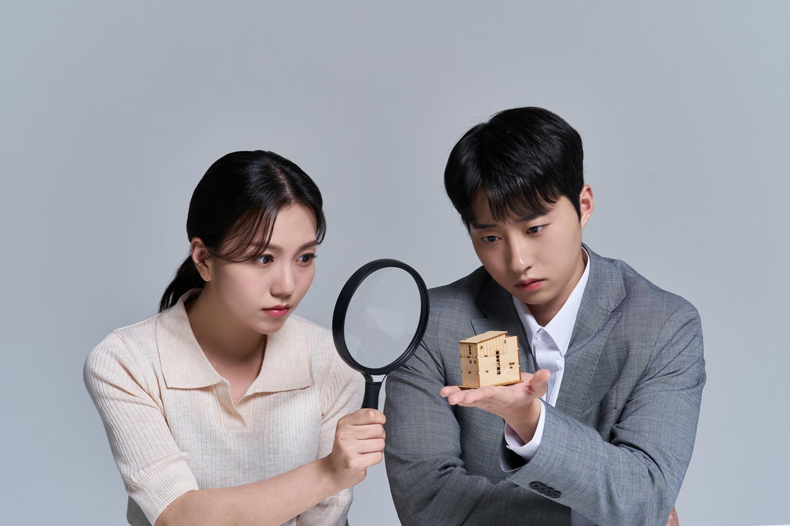 주택 모형을 손에 올려두고 돋보기로 살펴보는 모습. 30년 이상 고정금리 주택담보대출 확대 논의 속에서 대출 조건과 금리 구조를 신중히 비교·검토하는 차주의 상황을 상징적으로 보여준다. 게티이미지뱅크