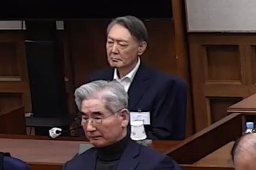 선고내용 듣는 尹 윤석열 전 대통령이 19일 오후 서울 서초구 서울중앙지법에서 열린 내란 우두머리 혐의 1심 선고공판에 출석해 피고인석에 앉아 굳은 표정으로 재판장의 선고 내용을 듣고 있다. 이날 서울중앙지법 형사합의25부(부장판사 지귀연)는 윤 전 대통령에게 무기징역을, 김용현 전 국방부 장관(앞)에 대해선 징역 30년을 각각 선고했다. 서울중앙지법 재판 중계 화면 캡처