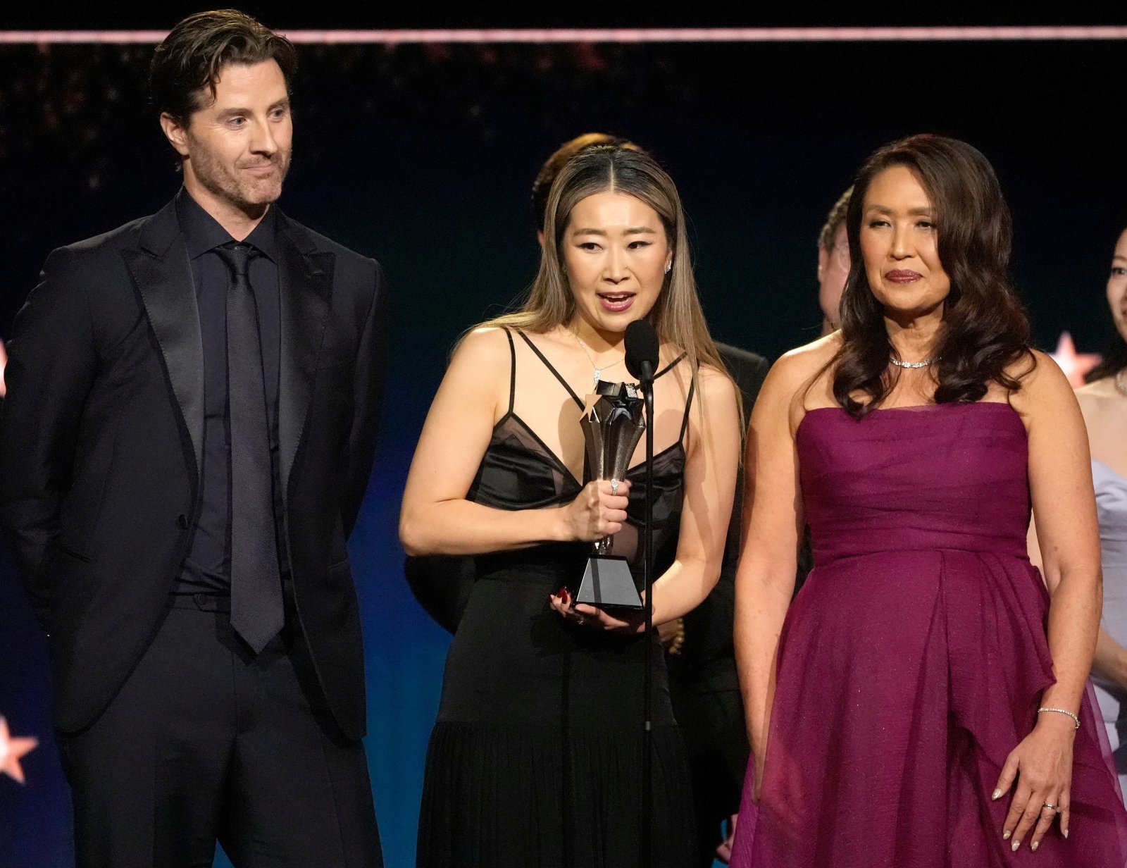 케이팝 데몬 헌터스(케데헌)의 매기 강(가운데) 감독이 4일(현지 시간) 미 캘리포니아주 산타모니카의 바커 행어에서 열린 제31회 크리틱스 초이스 어워즈에서 최우수 장편 애니메이션상을 받고 소감을 말하고 있다. 2026.01.05 산타모니카=AP 뉴시스