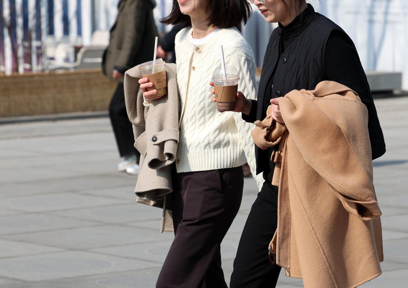 포근한 날씨를 보인 20일 오후 서울 종로구 광화문광장에서 외투를 손에 든 시민들이 걸어가고 있다. 2026.02.20. [서울=뉴시스]