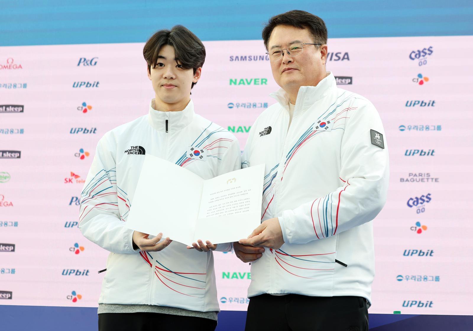 남자 계주 팀 주장 이준서(왼쪽)가 21일 밀라노 코리아하우스에서 김대현 문화체육관광부 차관으로부터 이재명 대통령의 축전을 받고 있다. 밀라노=뉴스1