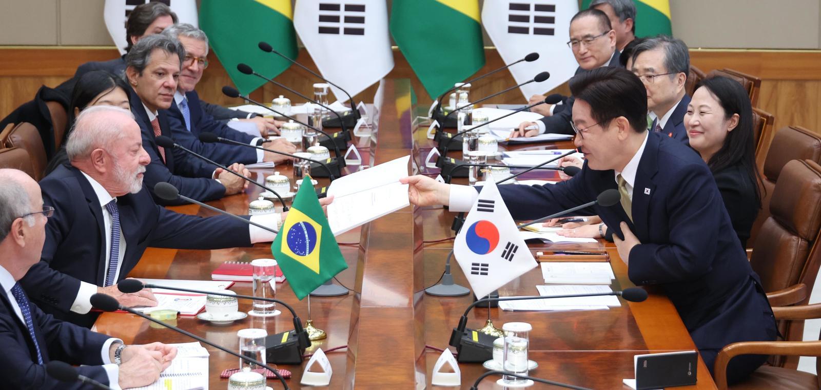 이재명 대통령이 23일 청와대에서 열린 한-브라질 확대 정상회담에서 루이스 이나시우 룰라 다 시우바 대통령이 요청한 책자에 사인 후 전달하고 있다. 뉴스1