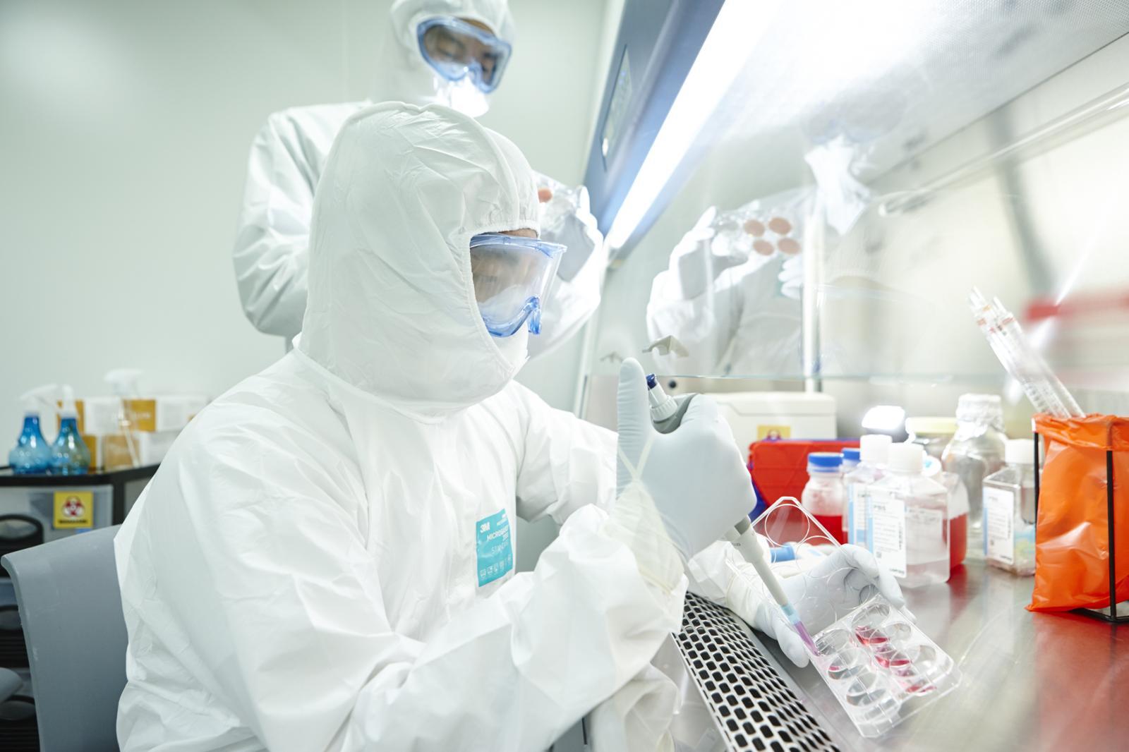 방호복을 착용한 고려대의료원 연구진이 실험실에서 연구를 수행하고 있다.