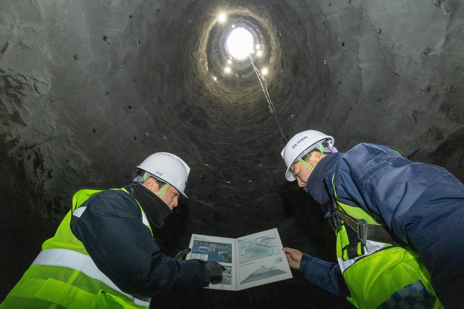 부산항신항 북측 컨테이너부두 2단계 항만배후단지 조성 공사 현장 수직터널 내부에서 관계자가 굴착 작업을 지휘하고 있다. DL이앤씨 제공