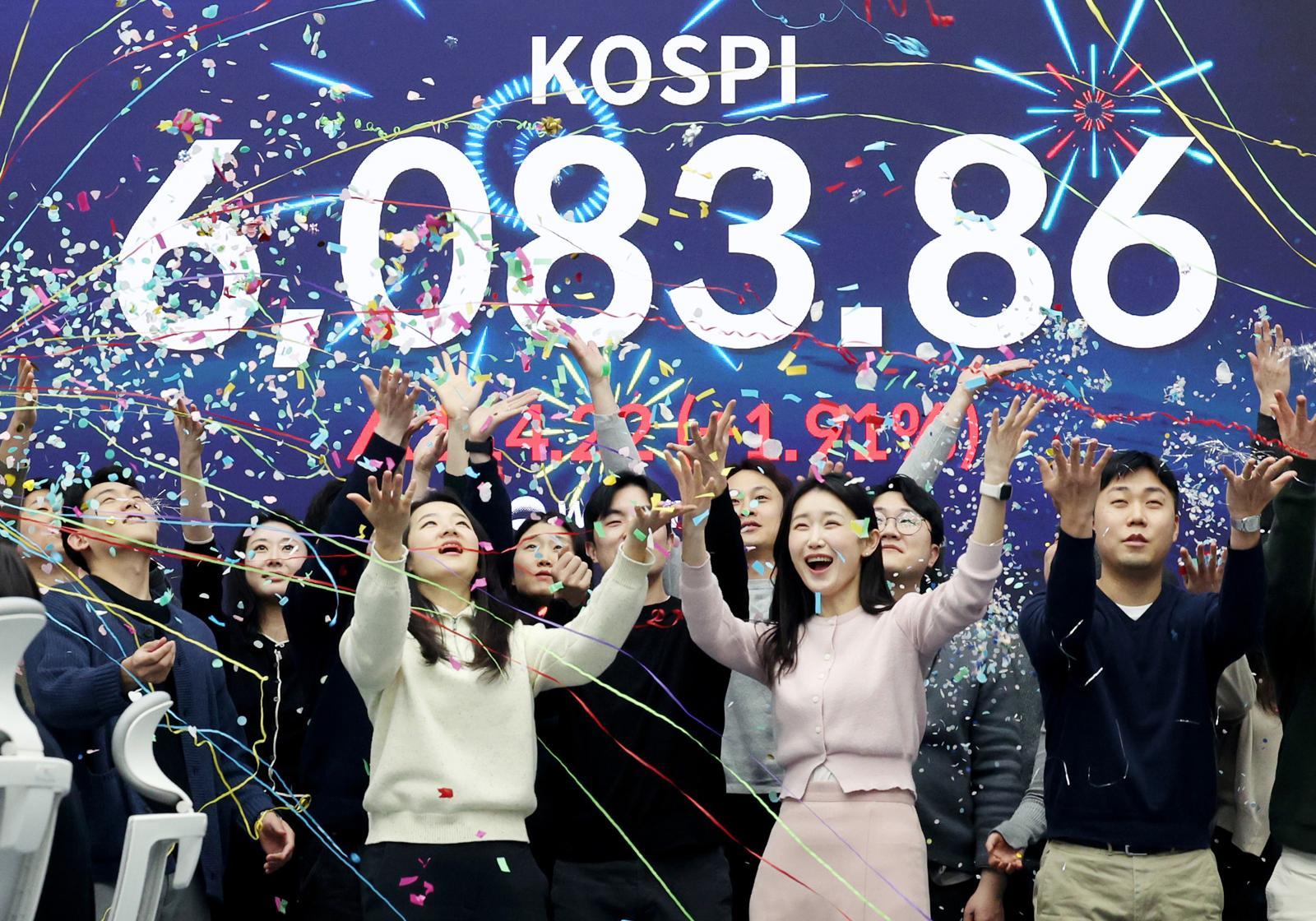 코스피가 사상 첫 6000을 돌파한 25일 서울 중구 우리은행 딜링룸에서 직원들이 축하 세리머니를 하고 있다.   25일 코스피는 전 거래일(5969.64)보다 114.22포인트(1.91%) 오른 6083.86에, 코스닥 지수는 전 거래일(1165.00)보다 0.25포인트(0.02%) 상승한 1165.25에 거래를 마쳤다. 2026.02.25. 서울=뉴시스