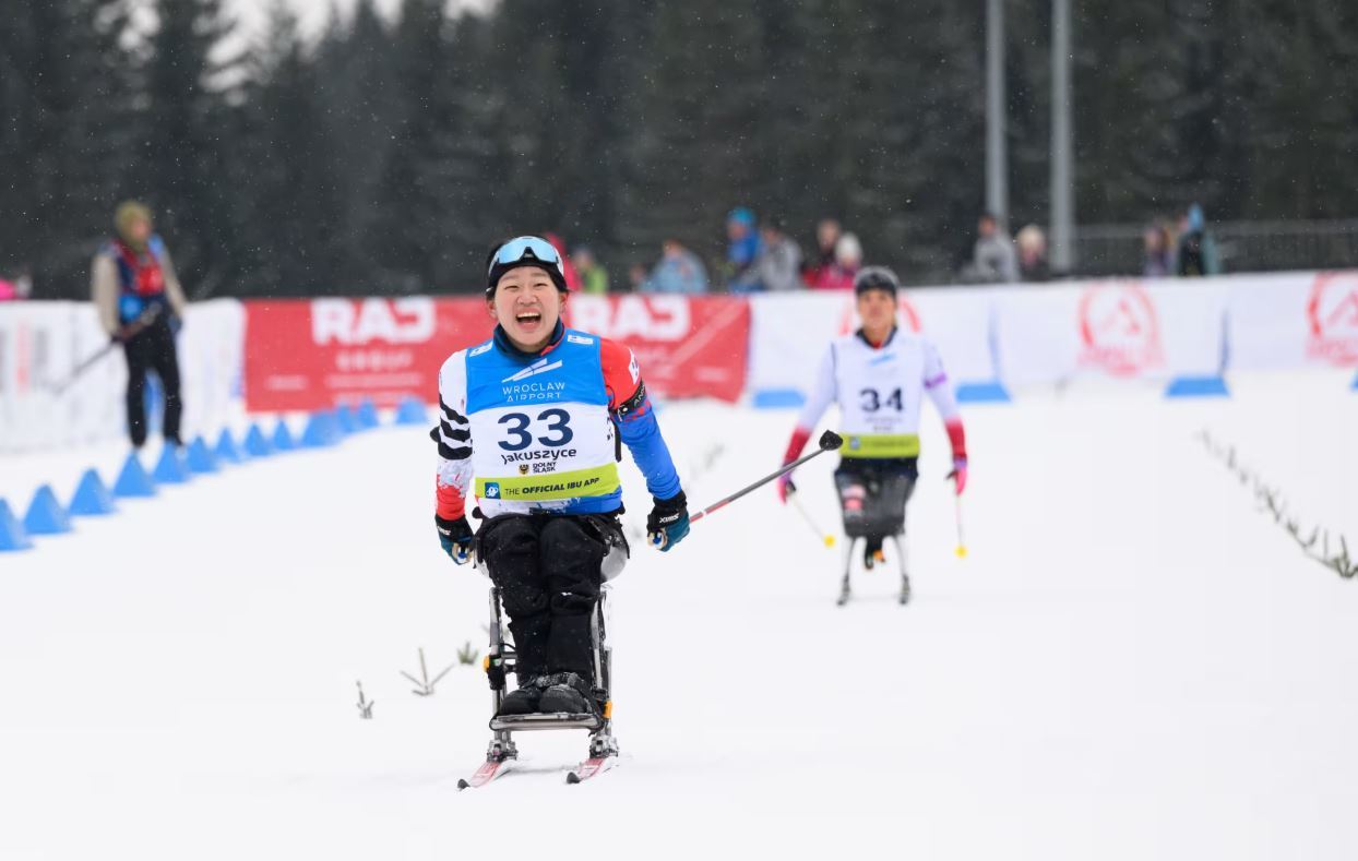 ‘한국 장애인 노르딕스키 간판’ 김윤지가 지난달 25일 폴란드 야쿠시체에서 열린 2026 IBU 파라바이애슬론 월드컵에서 1위로 결승선을 통과하며 해맑게 미소 짓고 있다. IBU 홈페이지 캡처