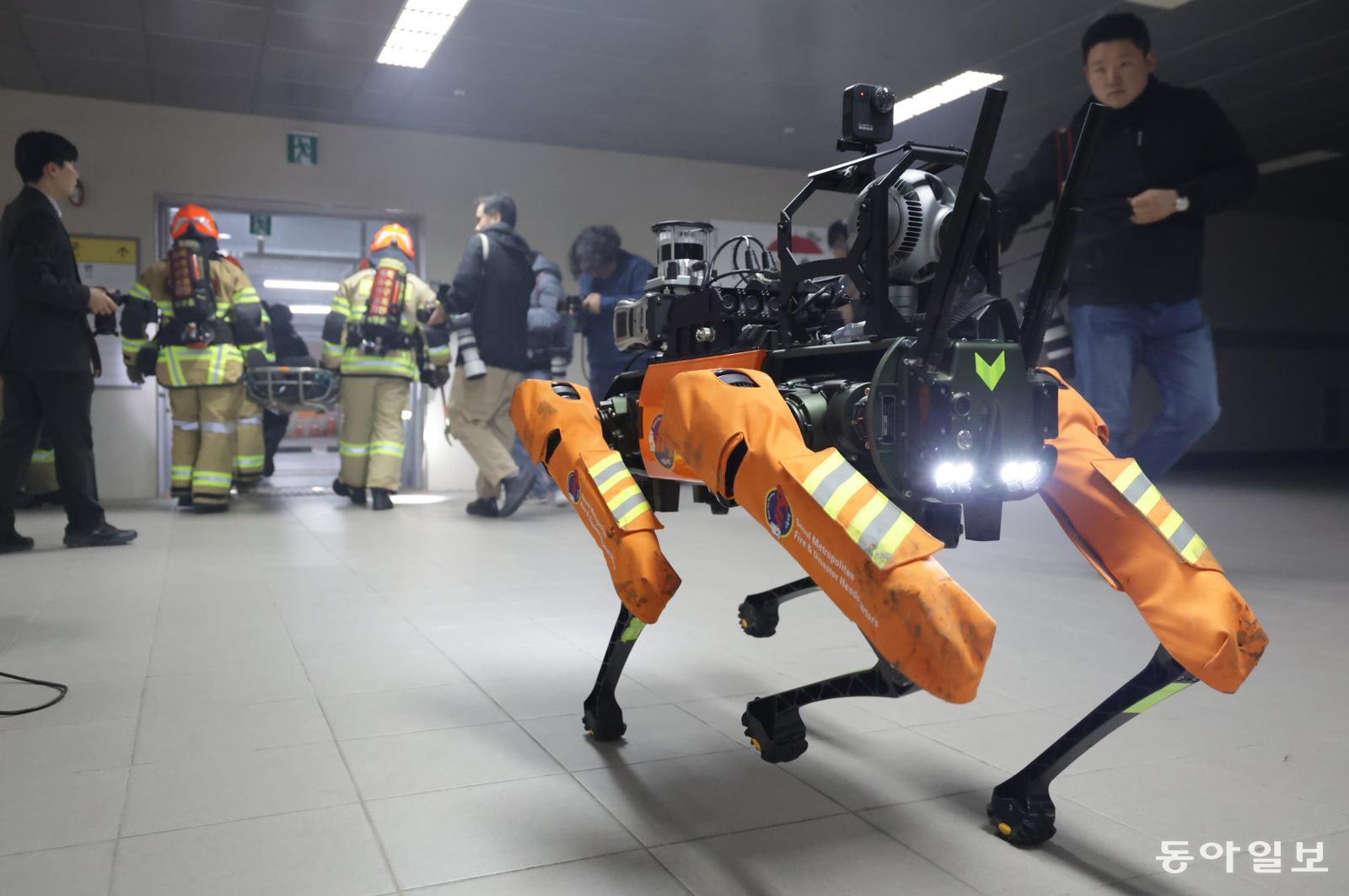 26일 서울 은평구 서울소방학교에서 열린 ‘미래형 재난 대응 체계 시연’ 행사에서 열화상 카메라가 달린 4족 보행 로봇이 소방대원들과 함께 연기 속에서 쓰러진 사람을 구조하는 시범을 보이고 있다. 박형기 기자 oneshot@donga.com