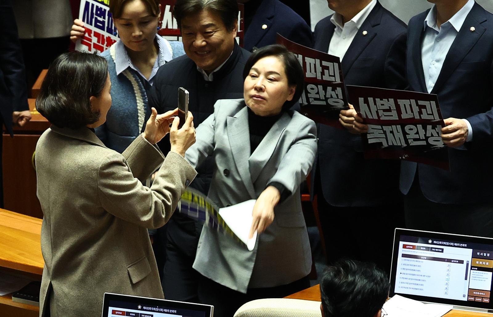 서명옥 국민의힘 의원이 27일 오후 서울 여의도 국회 본회의에서 ‘사법개혁 3법 반대’ 관련 구호가 적힌 현수막과 피켓을 들고 항의 하던 도중 이를 촬영하는 이해민 조국혁신당 의원의 핸드폰을 피켓으로 내리치려 하고 있다. 2026.02.27. 서울=뉴시스