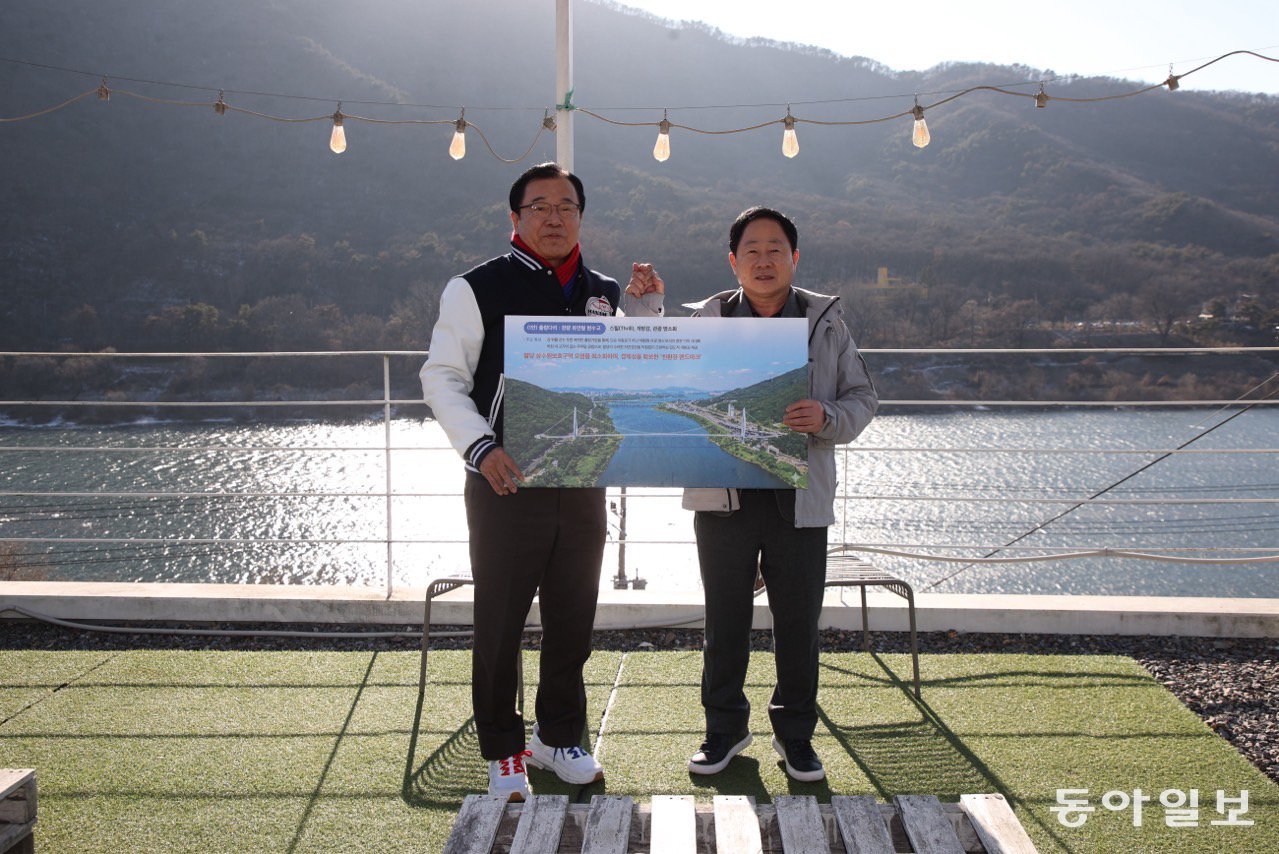 이현재  하남시장(왼쪽)과 주광덕 남양주시장이 올 1월 한강을 가로지르는 친환경 출렁다리 건설에 합의한 뒤 경기 남양주시에서 기념사진을 찍고 있다. 하남시 제공