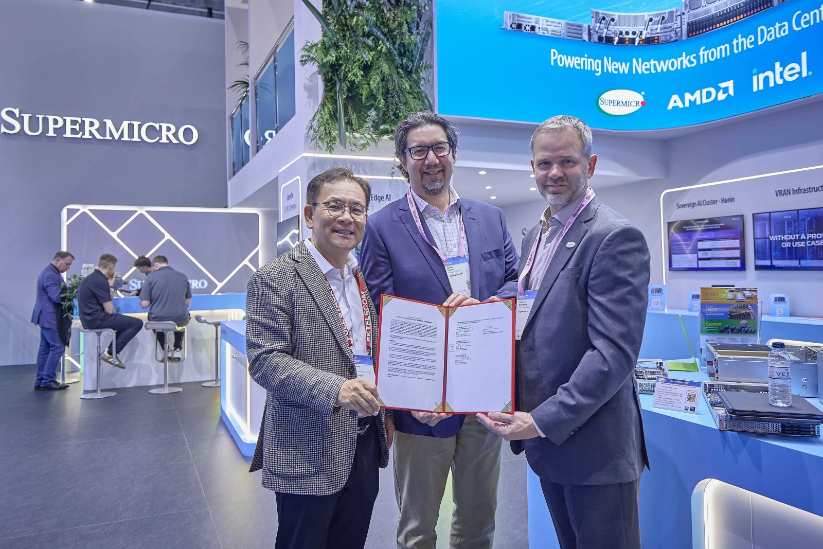 MWC26 슈퍼마이크로 전시관에서 기념 촬영 중인 (왼쪽부터) 하민용 SKT AI DC 사업 담당, 앤드류 브래드너 슈나이더 일렉트릭 수석 부사장, 클레이 시먼스 슈퍼마이크로 부사장의 모습.