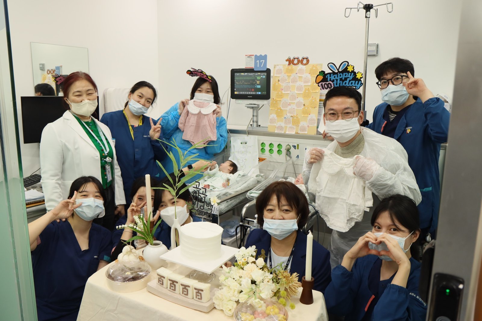 초극소저체중아 쌍둥이 자매의 100일을 맞아 일산차병원 신생아집중치료실 의료진과 부모가 함께 기념 촬영을 하고 있다.차 의과학대 일산차병원 제공