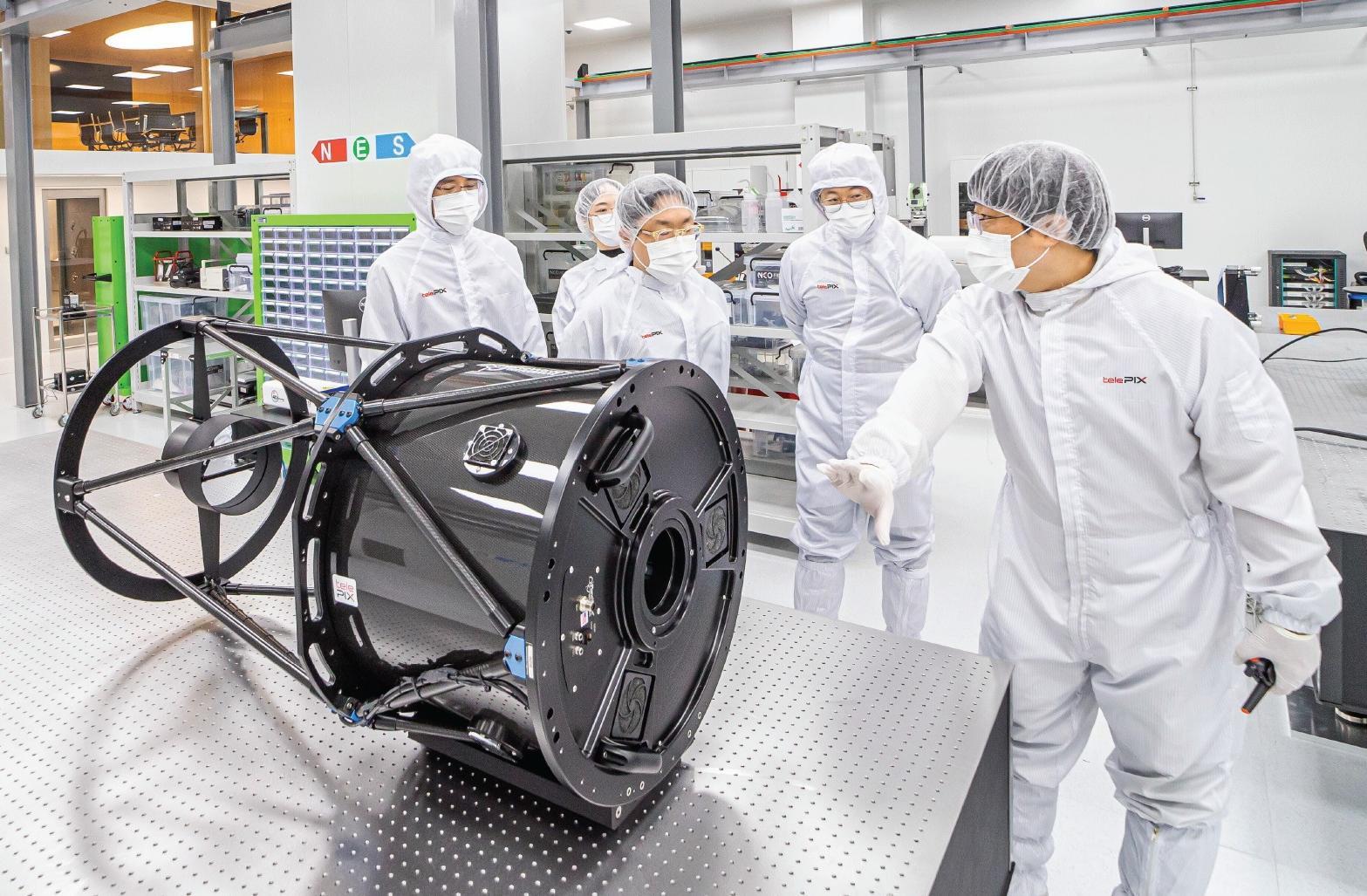 텔레픽스가 대전에 두고 있는 차세대 인공위성 광학탑재체 개발시설 스페이스랩 클린룸에서 조성익 대표(가운데)와 임직원들이 광학 부품 및 시스템의 조립 정렬과 성능 테스트에 쓰이는 대형 시준기를 살펴보고 있다. 텔레픽스 제공