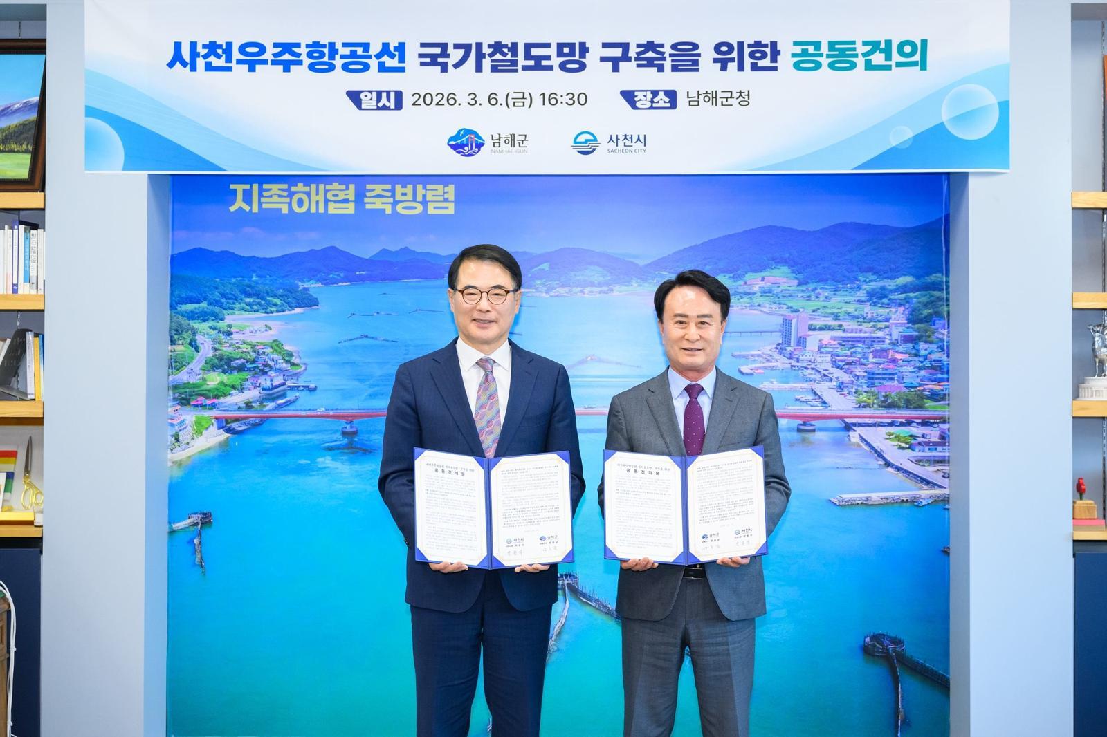 장충남 남해군수(왼쪽)와 박동식 사천시장이 6일 남해군청 군수실에서 사천우주항공선 국가철도망 구축 공동 건의문을 채택한 뒤 기념 촬영을 하고 있다. 남해군 제공