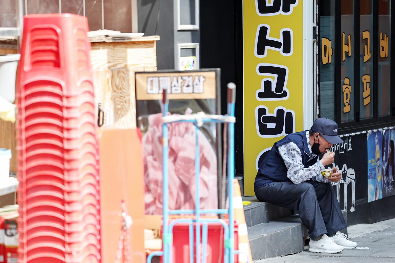 서울 종로구 탑골공원 인근 골목에서 한 어르신이 간편 죽으로 끼니를 때우고 있다. ⓒ 뉴스1