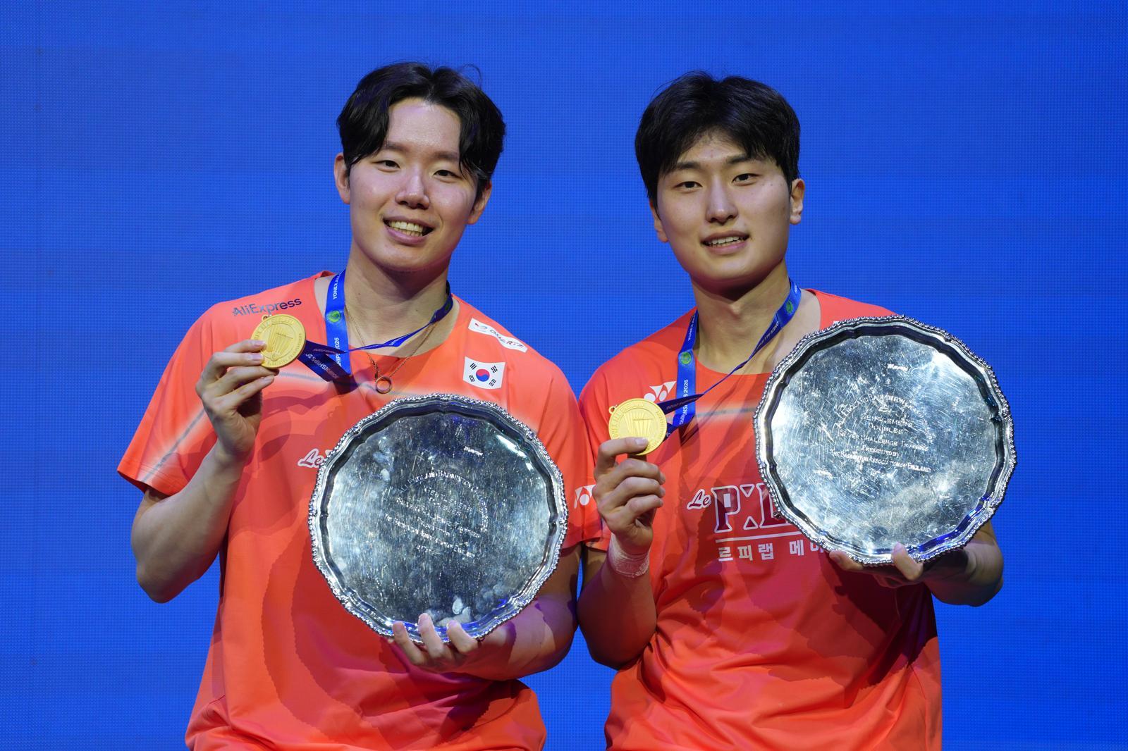 한국 배드민턴 남자 복식 듀오 서승재(왼쪽)와 김원호(오른쪽)가 9일 영국 버밍엄에서 열린 세계배드민턴연맹 전영오픈 남자 복식 결승에서 우승한 뒤 시상대에서 금메달을 들어 보이고 있다. 두 사람은 지난해에 이어 이 대회 2연패를 달성했다. 버밍엄=AP뉴시스