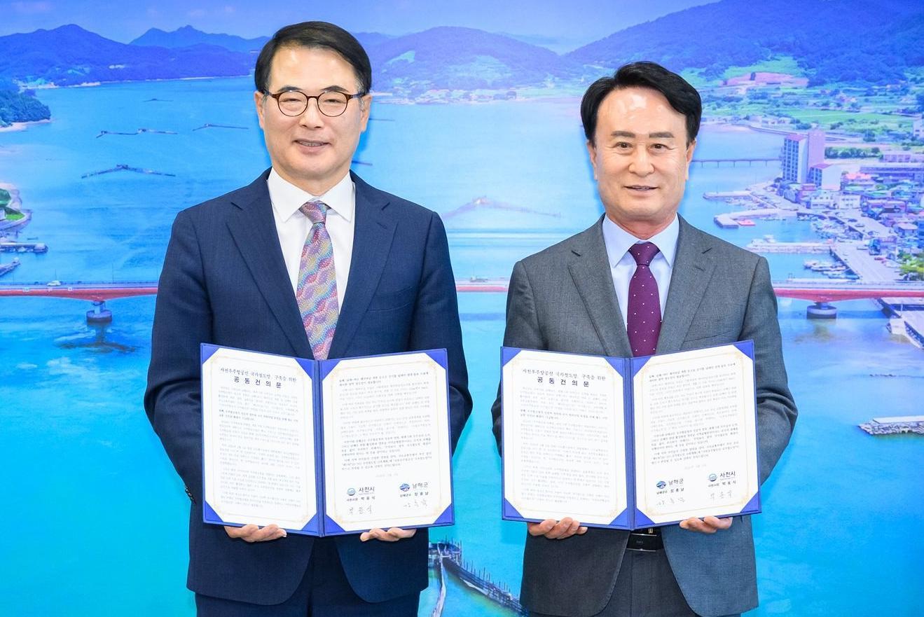 장충남 남해군수(왼쪽)와 박동식 사천시장이 6일 남해군청 군수실에서 사천우주항공선 국가철도망 구축계획 반영 공동 건의문을 채택한 뒤 기념 촬영을 하고 있다. 남해군 제공