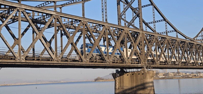 북한 평양에서 중국 베이징으로 향하는 여객 열차가 12일 오후 양국 국경을 잇는 압록강 철교(중조우의교)를 통과하고 있다. 단둥=뉴스1