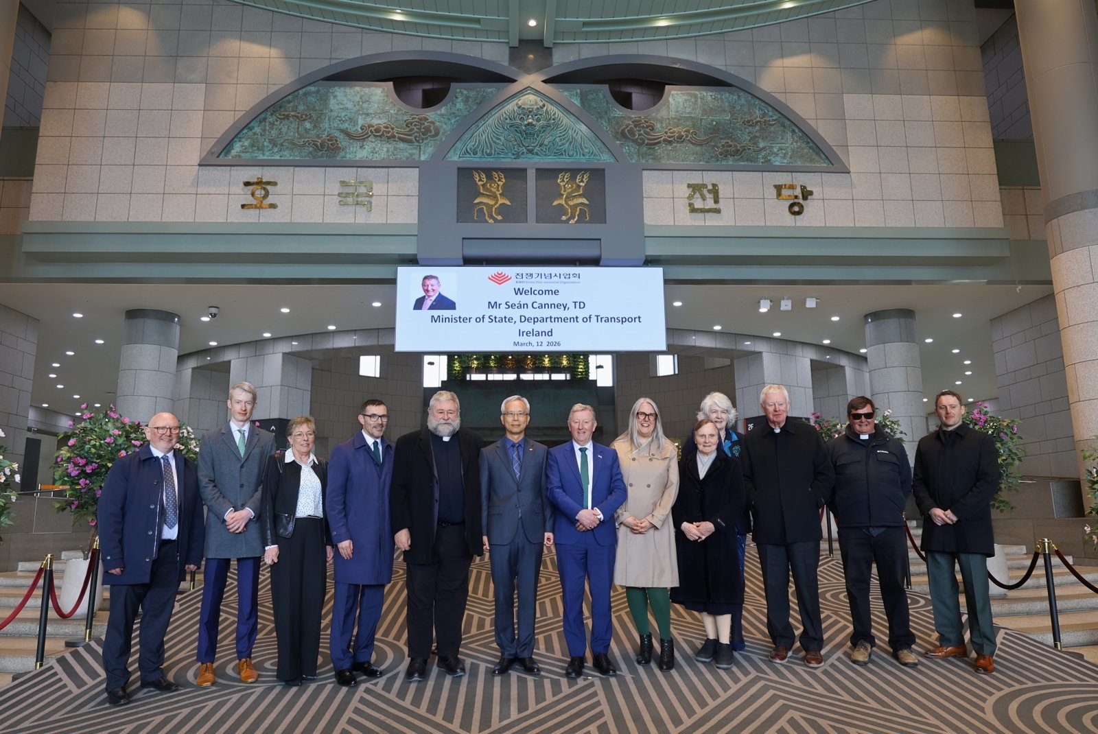 양동학  전쟁기념사업회 사무총장(왼쪽 끝에서 6번째)이 션 캐니(Seán Canney) 아일랜드 교통부 차관(오른쪽 끝에서 7번째), 미쉘 윈트럽 주한아일랜드대사(오른쪽 끝에서 6번째), 아일랜드 방한단, 성골롬반 외방선교회 관계자들과 전쟁기념관 중앙현관에서 기념촬영하고 있다.