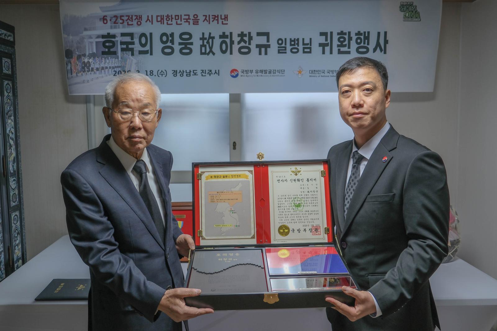 김성환 국방부 유해발굴감식단장 직무대리(왼쪽)가 18일 경남 진주시 고(故) 하창규 일병의 유가족 자택에서 열린 ‘호국의 영웅 귀환행사’에서 하 일병의 아들 종복 씨와 기념촬영을 하고 있다. 국방부 제공