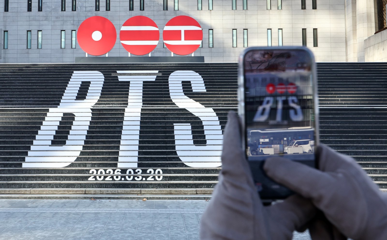 (서울=뉴스1) 서울 종로구 세종문화회관 계단에 설치된 방탄소년단(BTS)의 정규 5집 컴백을 알리는 홍보물을 배경으로 관광객들이 기념촬영을 하고 있다. 뉴스1