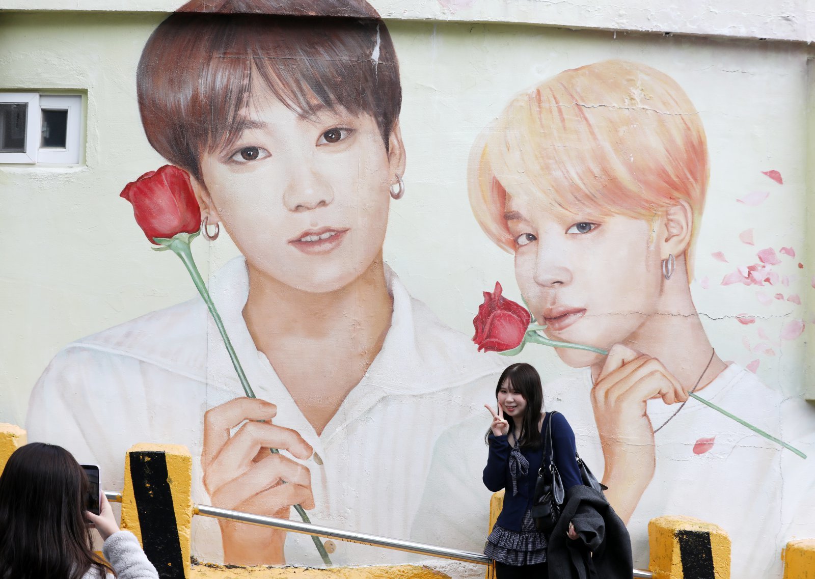 방탄소년단(BTS) 컴백 공연을 이틀 앞둔 19일 부산 서구 감천문화마을에서 외국인 관광객들이 부산이 고향인 BTS 멤버 정국·지민이 그려진 대형 벽화를 배경으로 기념촬영을 하고 있다. 뉴스1