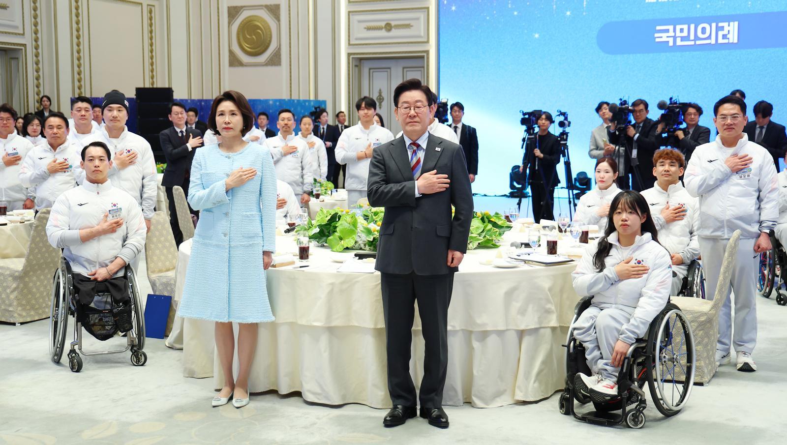 이재명 대통령과 김혜경 여사가 20일 청와대 영빈관에서 열린 밀라노-코르티나 동계 패럴림픽 선수단 격려 오찬에서 참석자들과 국민의례를 하고 있다. 뉴시스