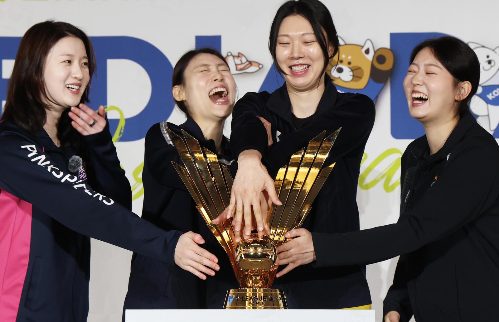 여자 프로배구 선수들이 트로피와 함께 웃고 있는 모습