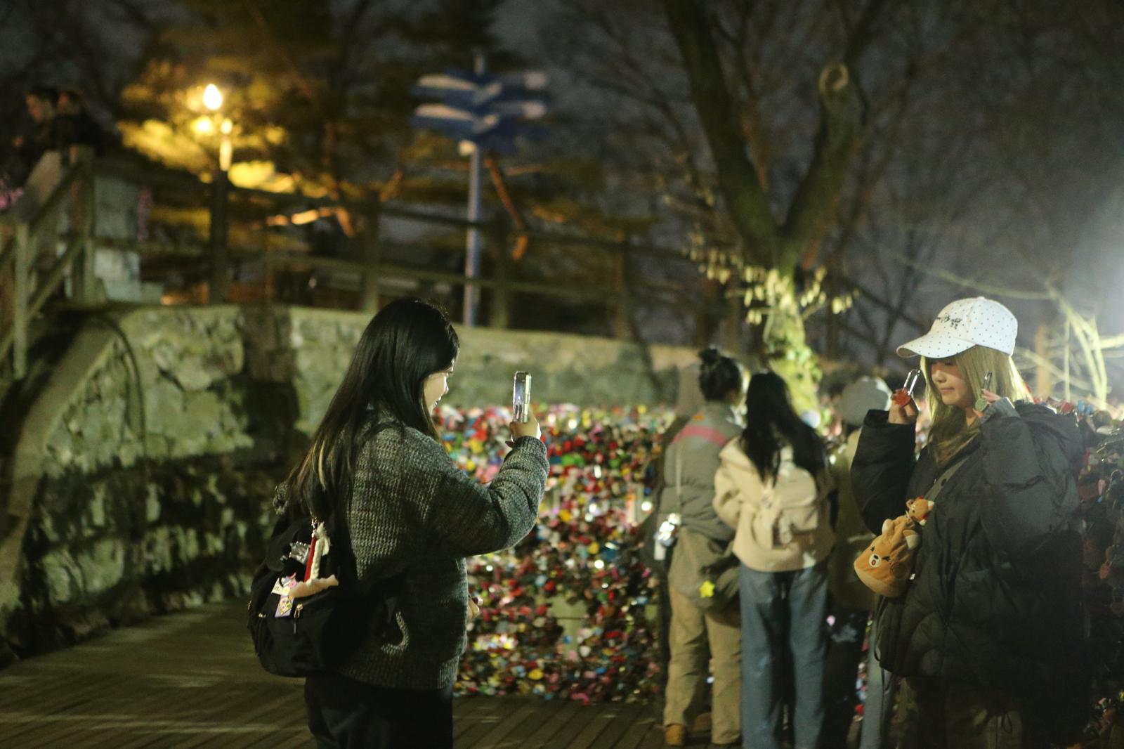 쌀쌀한 날씨에도 외국인 팬들이 남산타워 앞에 모여 BTS 전야 행사를 관람하며 사진과 영상을 남기고 있다. 김영호 기자 rladudgh2349@donga.com