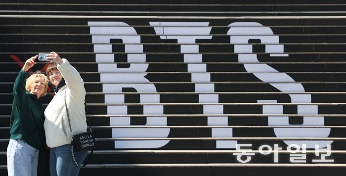 BTS의 광화문광장 공연을 일주일여 앞둔 3월 13일 서울 종로구 세종문화회관 계단을 장식한 BTS 로고 앞에서 외국인 관광객들이 사진을 찍고 있다. 동아DB