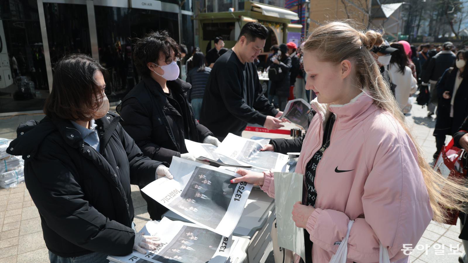 BTS 광화문 공연이 예정된 21일 오전 서울 종로구 동아미디어센터 앞에서 BTS 팬들이 동아일보 BTS 특별판 신문을 받아들고 있다. 박형기 기자 oneshot@donga.com