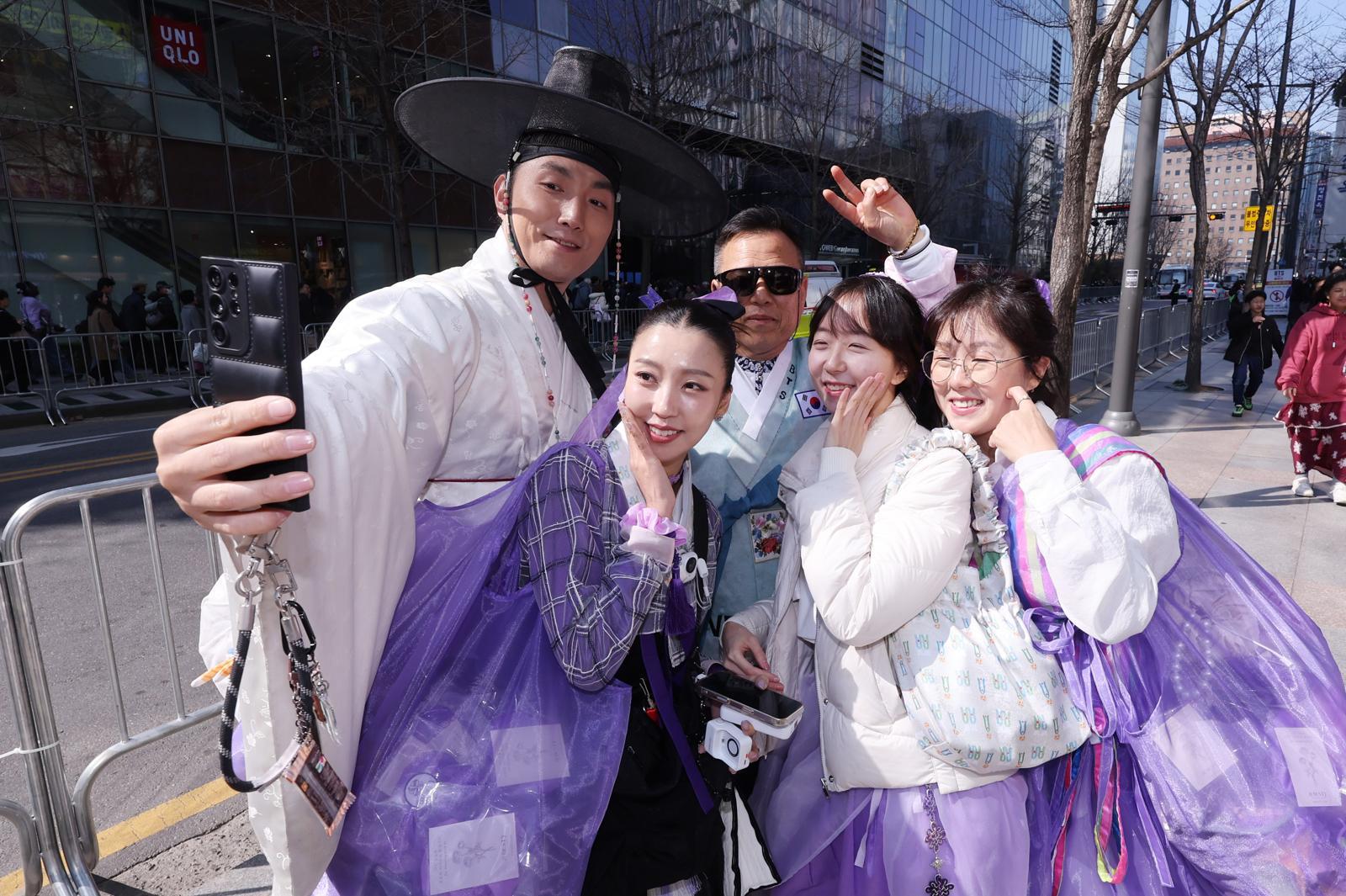 방탄소년단(BTS) 컴백 공연일인 21일 서울 광화문광장 인근에서 한복을 입은 아미들이 기념촬영을 하고 있다. 뉴스1