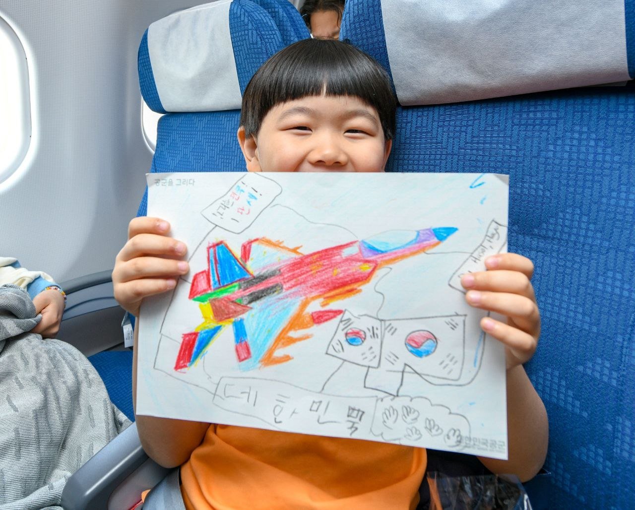 15일(현지 시간)공군 수송기(KC-330)에 탑승한 어린아이가 스케치북으로 그림을 그리고 있다. 2026.03.16. 사진= 국방부 제공