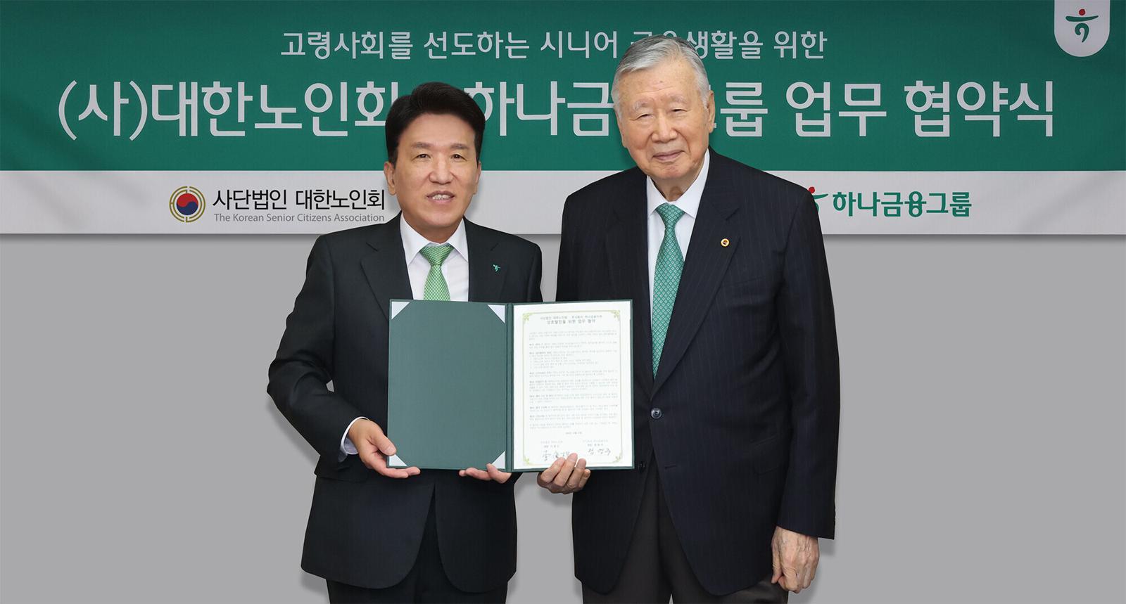 함영주 하나금융그룹 회장(왼쪽)이 지난해 12월 이중근 대한노인회장과 시니어 세대의 금융 생활 지원을 위한 상호 협약서를 들어 보이고 있다. 하나금융그룹 제공